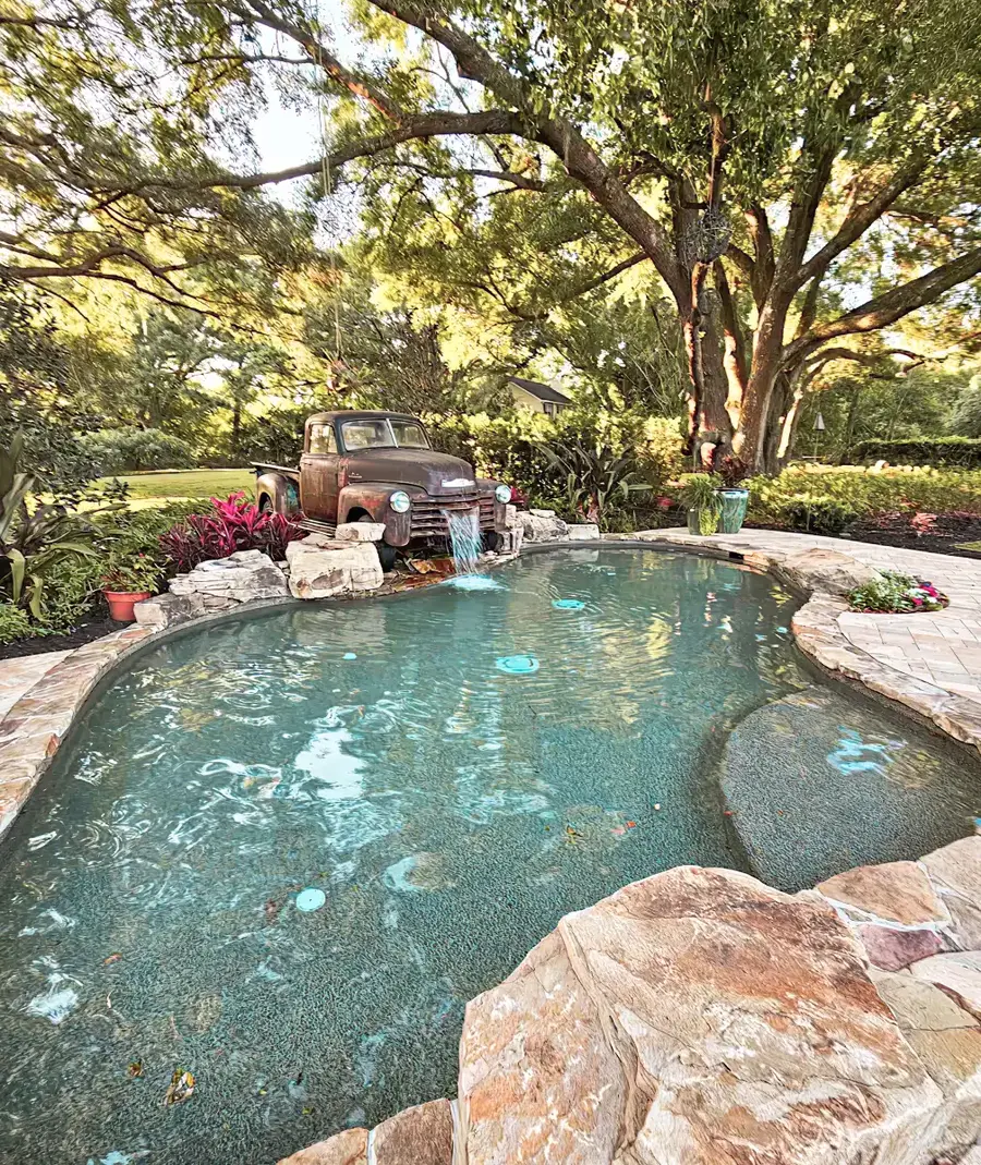 Finished freeform pool with rock waterfall and garden