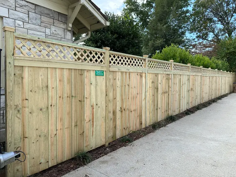 Wood privacy fence with lattice top along a sidewalk