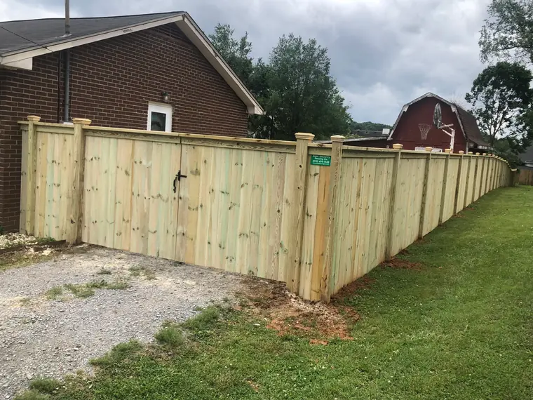 Gated side yard fence beside a brick house