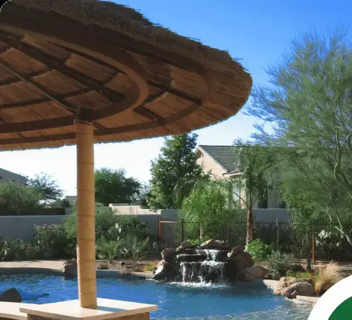 Custom pool with a thatched palapa and rock waterfall