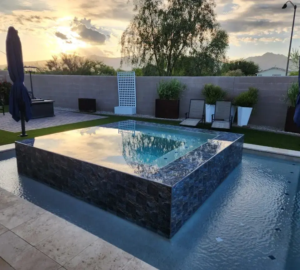 Raised spa with dark tile at sunset