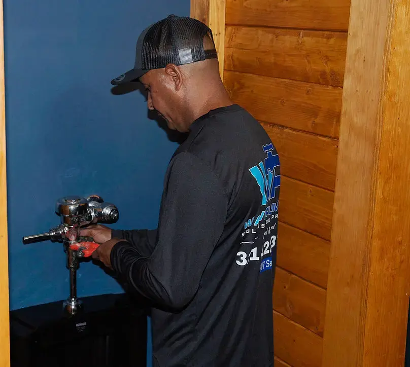 A Wave plumber at work on a water supply fixture