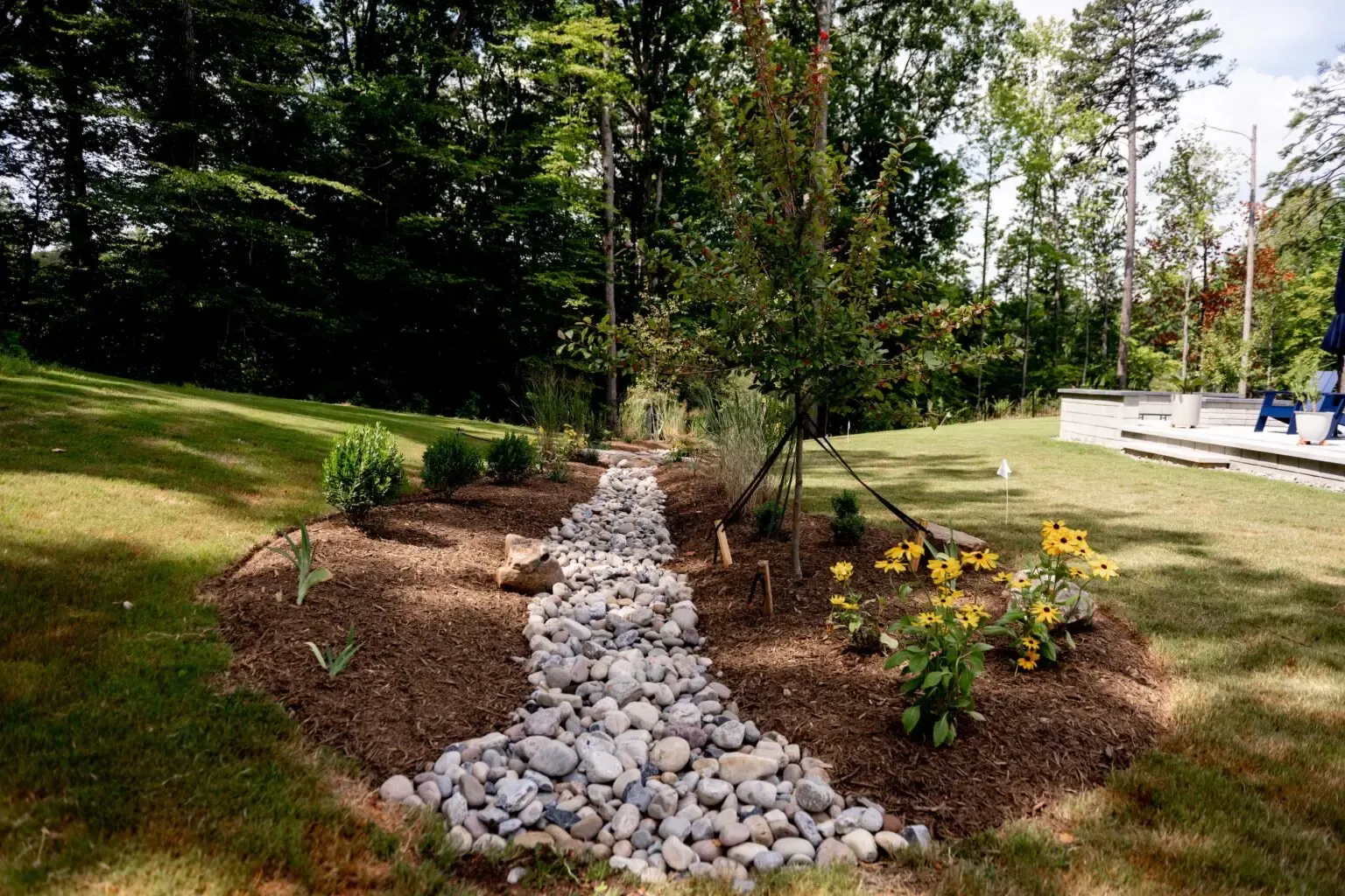 River rock swale through a planted bed